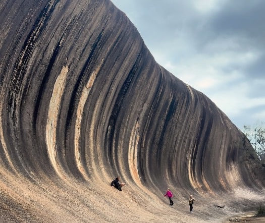 Wave Rock curling over the people below