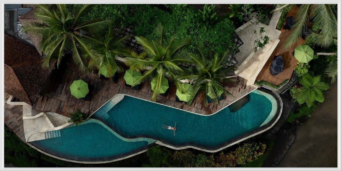An infinity pool surrounded by Ubud jungle, seen from above