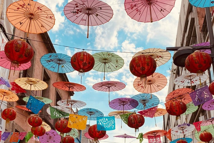 Paper parasols and red lanterns strung over a Mexico City street
